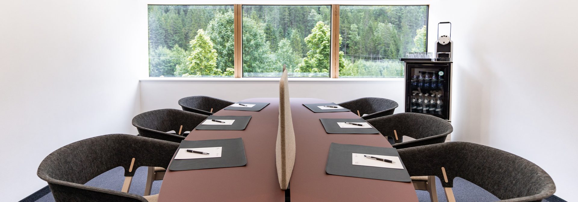 Ein workshopraum, in dem ein ovaler Tisch mit Bestuhlung für sieben Personen steht.
