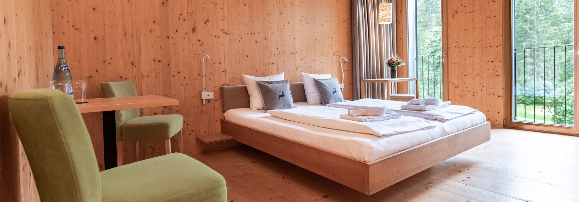 Innenansicht eines Holzverkleideten Zimmers des Alpenhotel Ammerwald. 